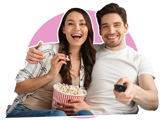 Frau und Mann lachend mit Popcorn beim Fernsehen